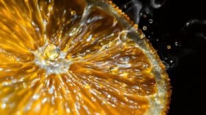 Close-up of a juicy orange slice with droplets splashing.