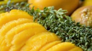 Close-up of fresh mango slices and herbs