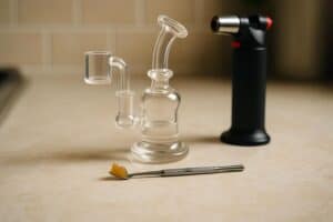 a dab rig, torch, and tool with wax on it