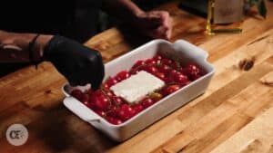 A block of feta and cherry tomatoes in a dish