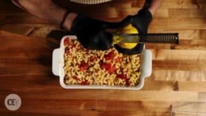 Combining the ingredients in a dish, lemon-peel zest being added by hand