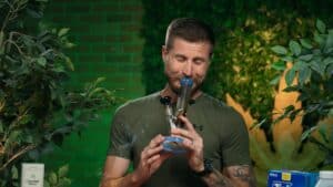 Cannabis lifestyle tutorial featuring a person demonstrating cleaning a bong.