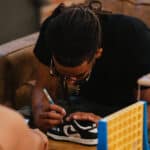 An artist putting a creative twist on some toddler sneakers.